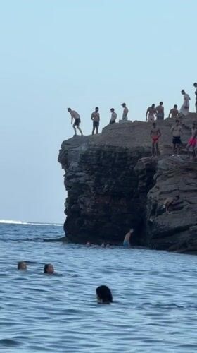 Cliff jumping off the rocky Budva coastline, Montenegro
