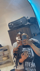 Two women take mirror selfies in Abuja room