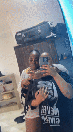 Two women take mirror selfies in Abuja room