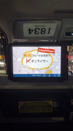 Taxi passenger observes cartoon advertisement on seat-back screen