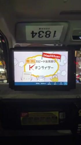 Taxi passenger observes cartoon advertisement on seat-back screen
