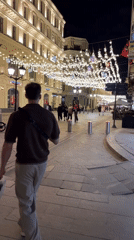 Man with shopping bag walks Moscow pedestrian street at night