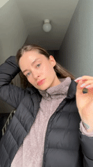 Woman adjusts hair in Kiel stairwell