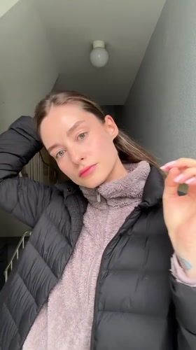 Woman adjusts hair in Kiel stairwell