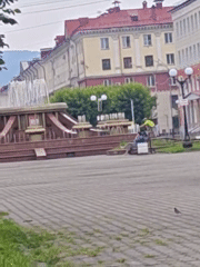 Pigeons, a fountain, and an accordion-playing alligator statue in a city square