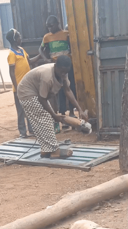Metal workers cut gates with grinders in Akwanga