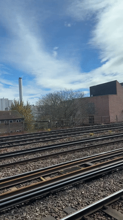 Train passenger films industrial railway view in sunny London