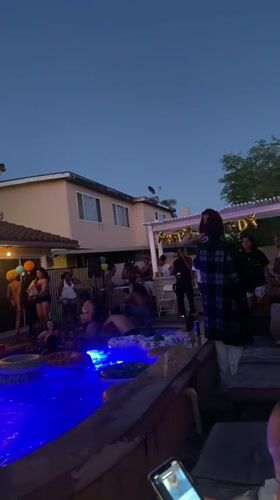 Late-night pool party in a Cypress backyard, blue lights and balloons