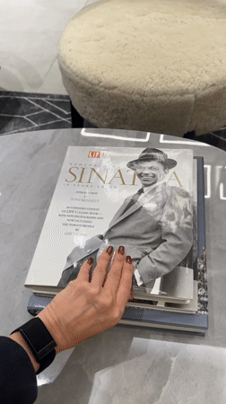 Dubai resident reads Sinatra magazine, walks in flowing garment