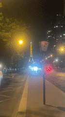 Eiffel Tower glowing at night above the Seine