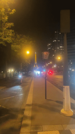Eiffel Tower glowing at night above the Seine