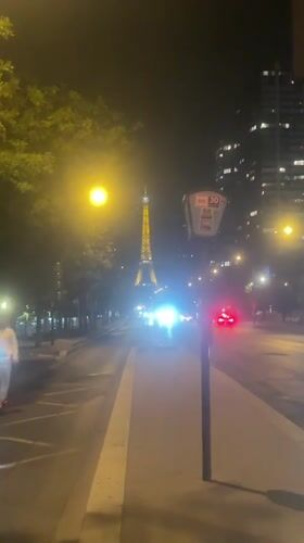Eiffel Tower glowing at night above the Seine