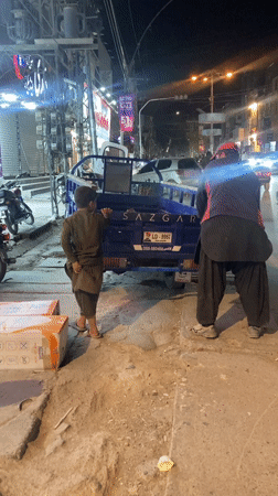 Boy boards three-wheeled vehicle on Quetta street