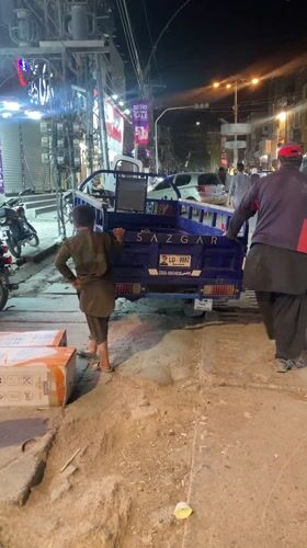 Boy boards three-wheeled vehicle on Quetta street
