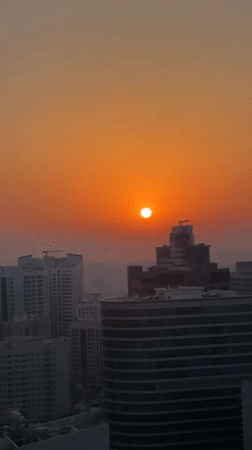 Dubai skyline glows under a hazy summer sunset