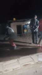 Late-night outdoor dancing in a dimly lit open-air spot