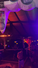 Nightclub patrons dance under colorful lights in Ban Tai, Thailand