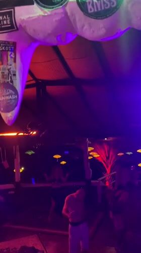 Nightclub patrons dance under colorful lights in Ban Tai, Thailand