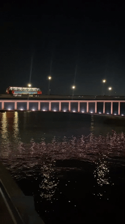 Pink-lit Thames bridge and city skyline after dark