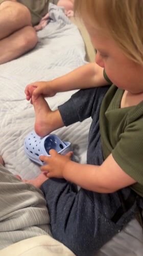 Child puts on shoes in Bat Yam bedroom