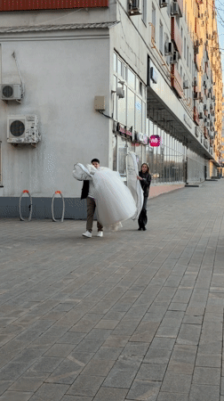 Wedding dress transported on Moscow sidewalk
