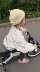 Child rides training wheel bicycle in early morning Moscow