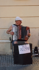 Accordion player busking on a Warsaw street, BLIK payments accepted