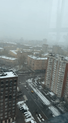 Spring snowfall blankets Moscow cityscape in early morning