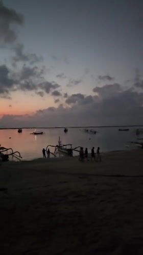 Sanur Beach at dusk: boats, walkers, and fading light