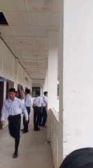 Students in uniforms walk through school hallway