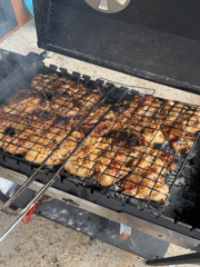 Person grills chicken on charcoal in Подшивалово, Russia