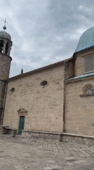 Tourist documents historic churches in Perast, Montenegro
