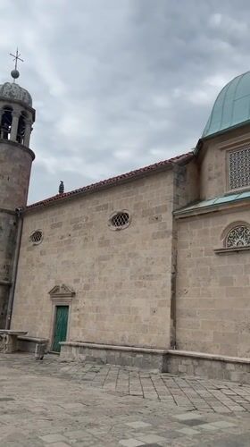 Tourist documents historic churches in Perast, Montenegro