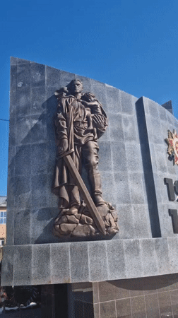 Woman brings flowers to WWII memorial in Otchor, Russia