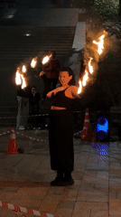 Fire dancer performs torch routine in nighttime Vladivostok street