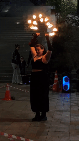 Fire dancer performs torch routine in nighttime Vladivostok street