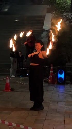 Fire dancer performs torch routine in nighttime Vladivostok street