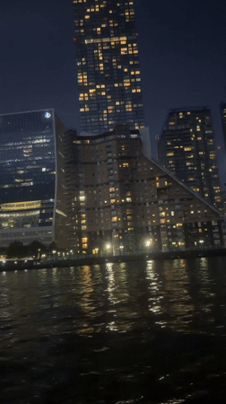 London skyline lights shimmer across Thames in evening footage