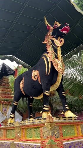 Tourist documents Balinese temple art and Hindu statues in Ubud