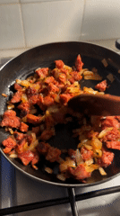 Home cook prepares arepas with sausage in Barcelona kitchen