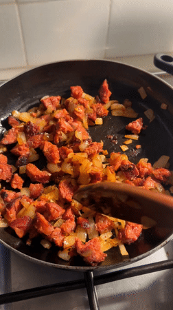 Home cook prepares arepas with sausage in Barcelona kitchen