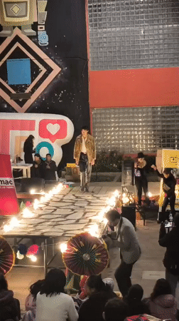 Outdoor runway show in La Paz, flames and geometric mural backdrop