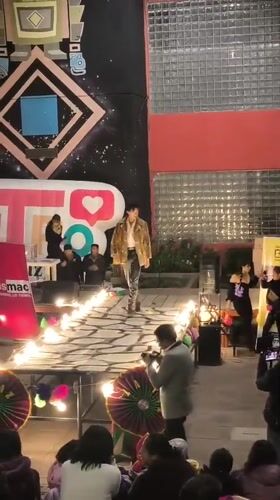 Outdoor runway show in La Paz, flames and geometric mural backdrop