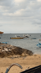 Quiet afternoon on a Bali beach with boats and surf rentals