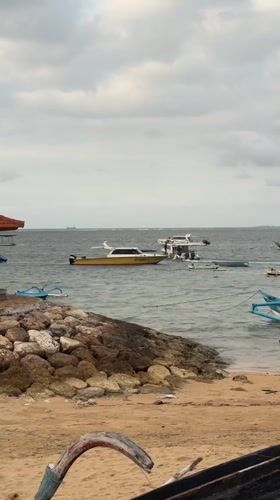Quiet afternoon on a Bali beach with boats and surf rentals
