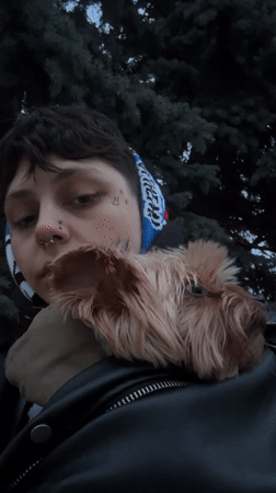 Person poses with Yorkshire Terrier during outdoor photoshoot in Voronezh