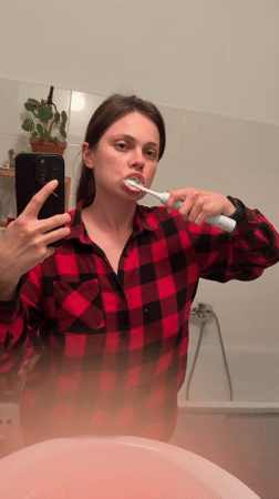 Woman records selfie video in Budapest bathroom mirror