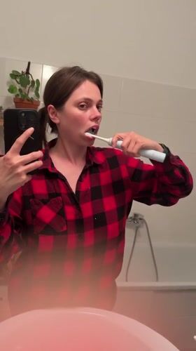 Woman records selfie video in Budapest bathroom mirror