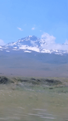 Scenic mountain drive past peaks, plains, and open water