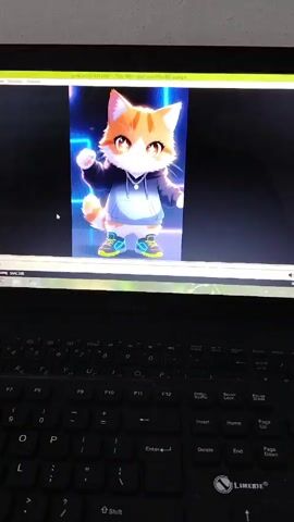 A laptop displays an animated character resembling a cat wearing a hoodie and sneakers. The animation shows the cat waving and bouncing. The screen is positioned above a black keyboard. The video is playing on a computer screen.